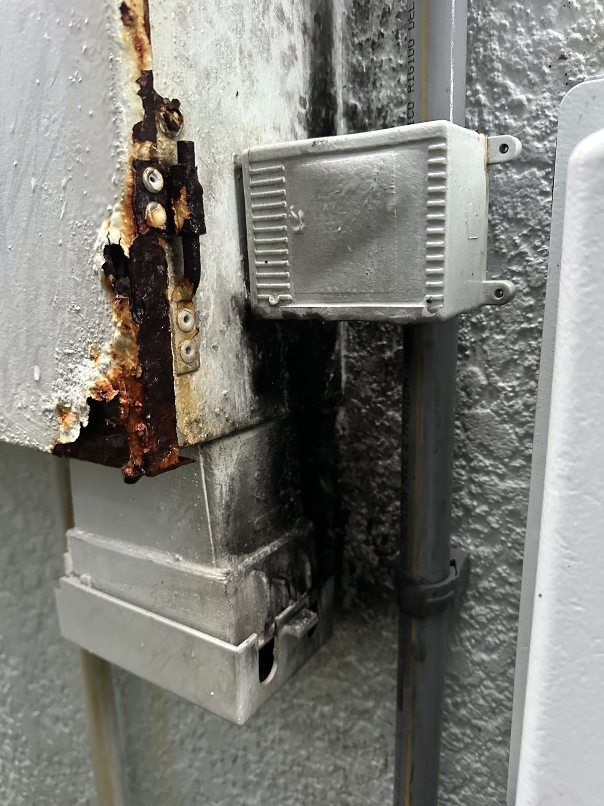 Corroded, fire-damaged panel before replacement — Hammock Beach